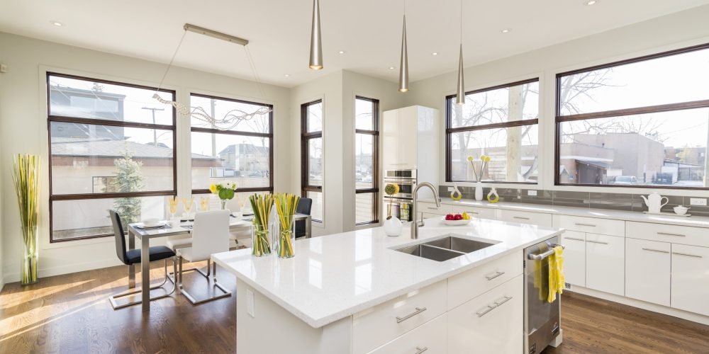 An interior shot of a modern house kitchen with large windows